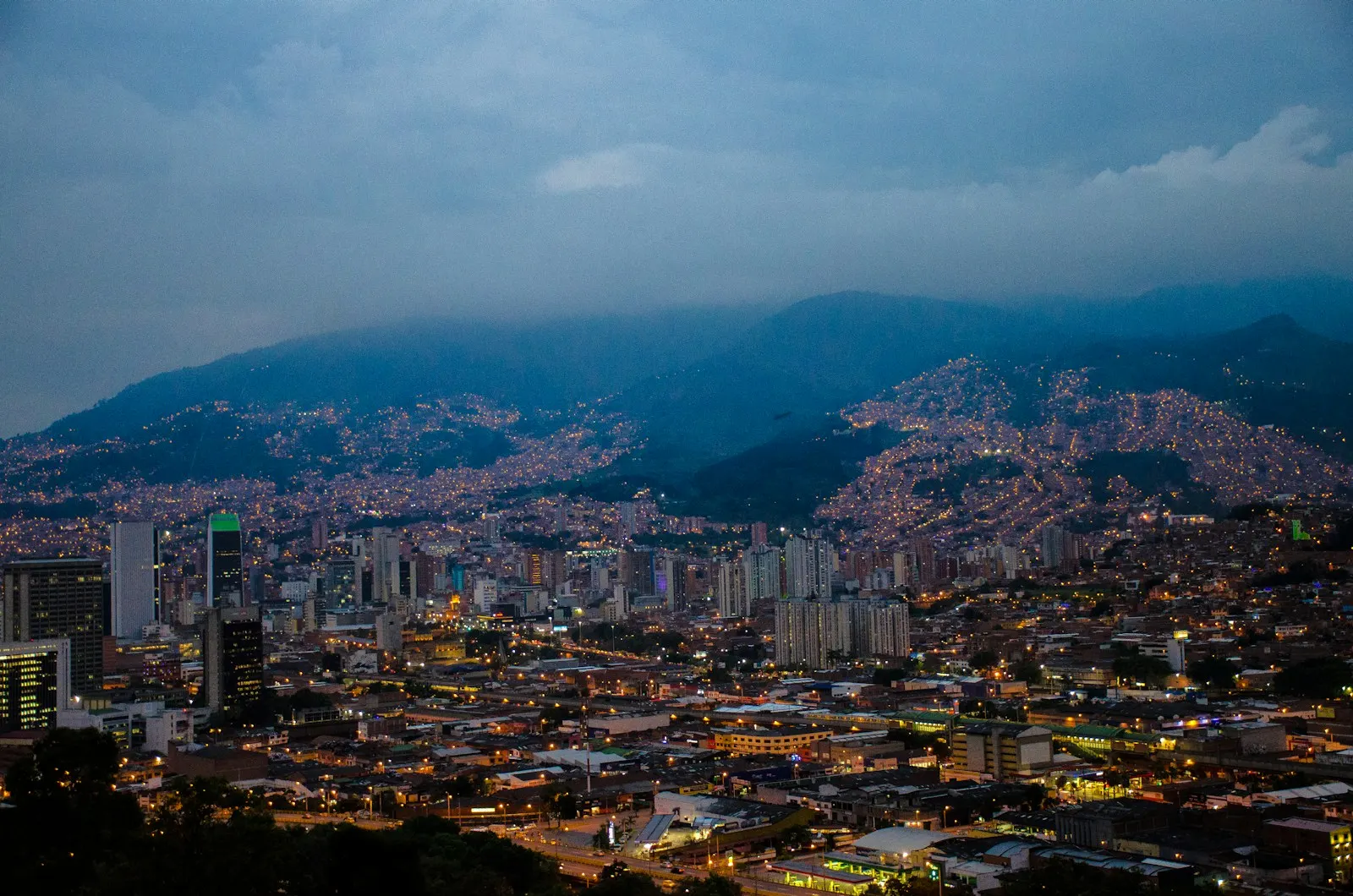 Medellín city panorama at dusk with lights illuminating the hillside neighbourhoods